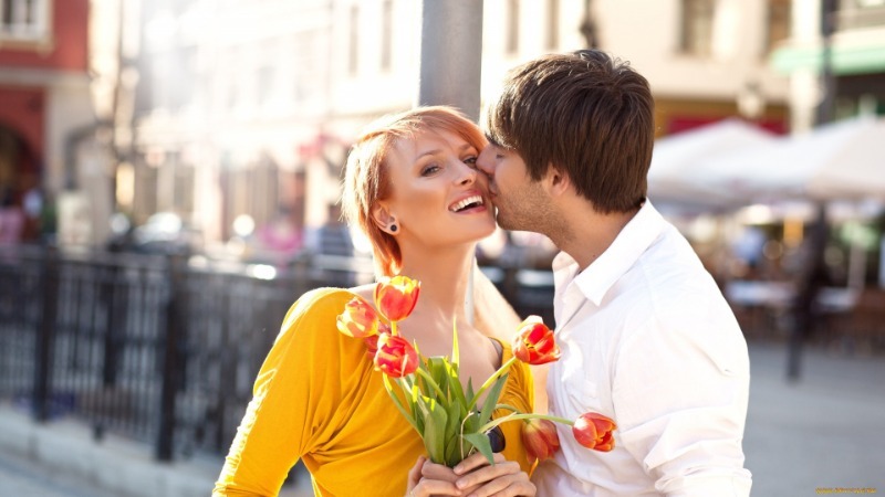 Парень целует девушку с тюльпанами